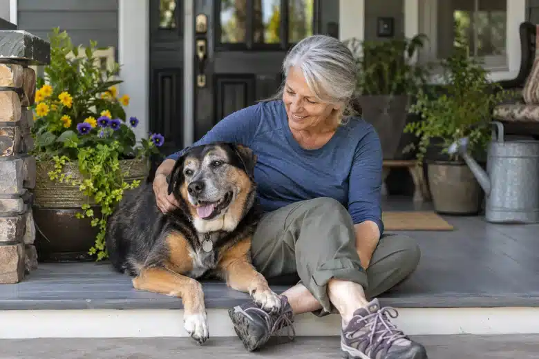Older civilian woman with her dog on a front porch