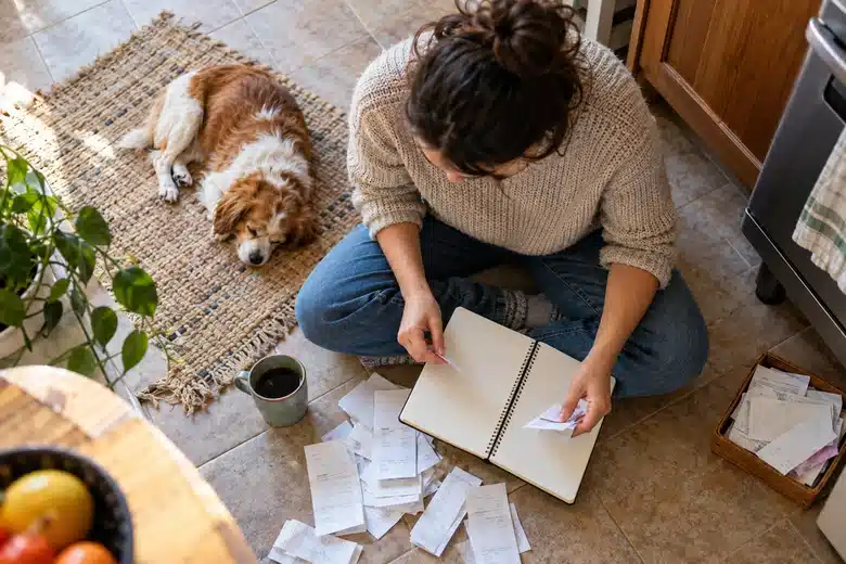 Small dog resting beside an owner working on household budgeting